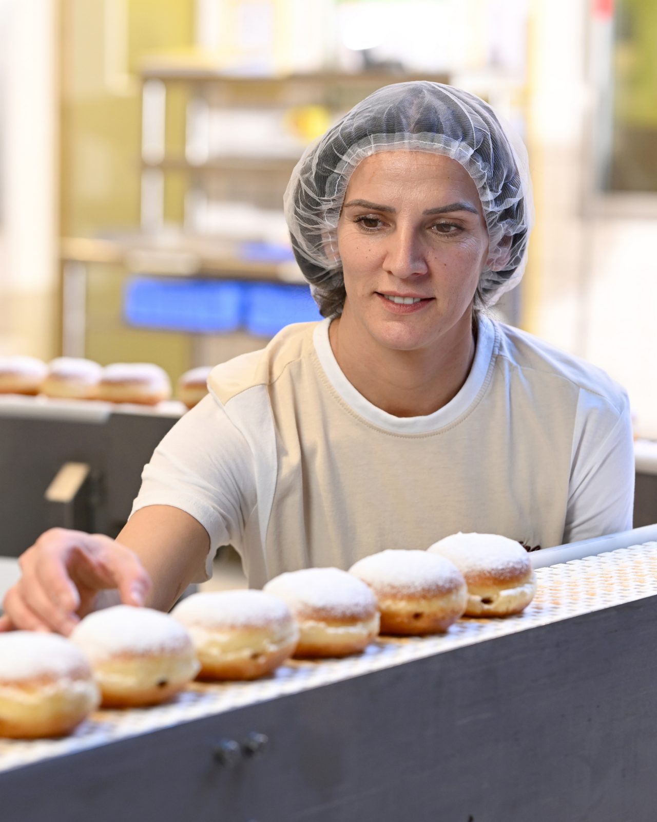 Mitarbeiterin in der Produktion wiegt Brot