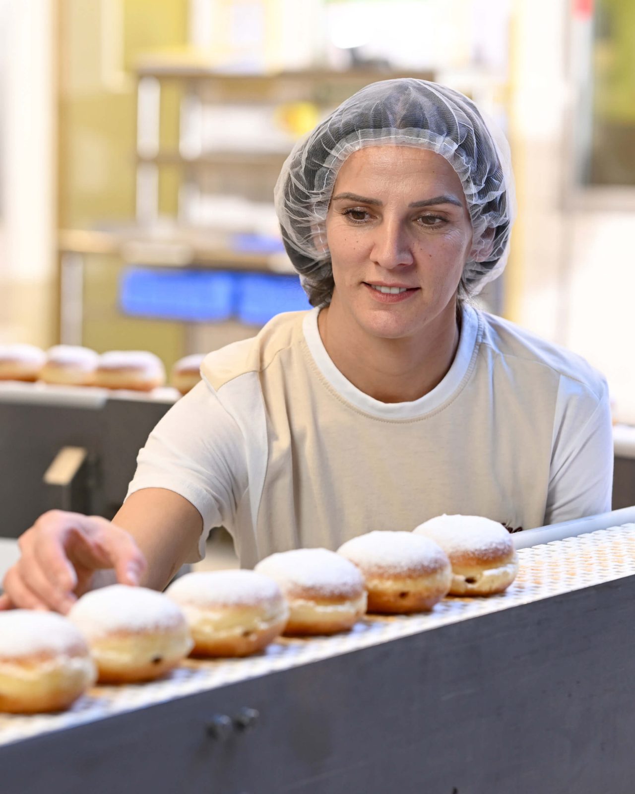 Mitarbeiterin in der Produktion wiegt Brot